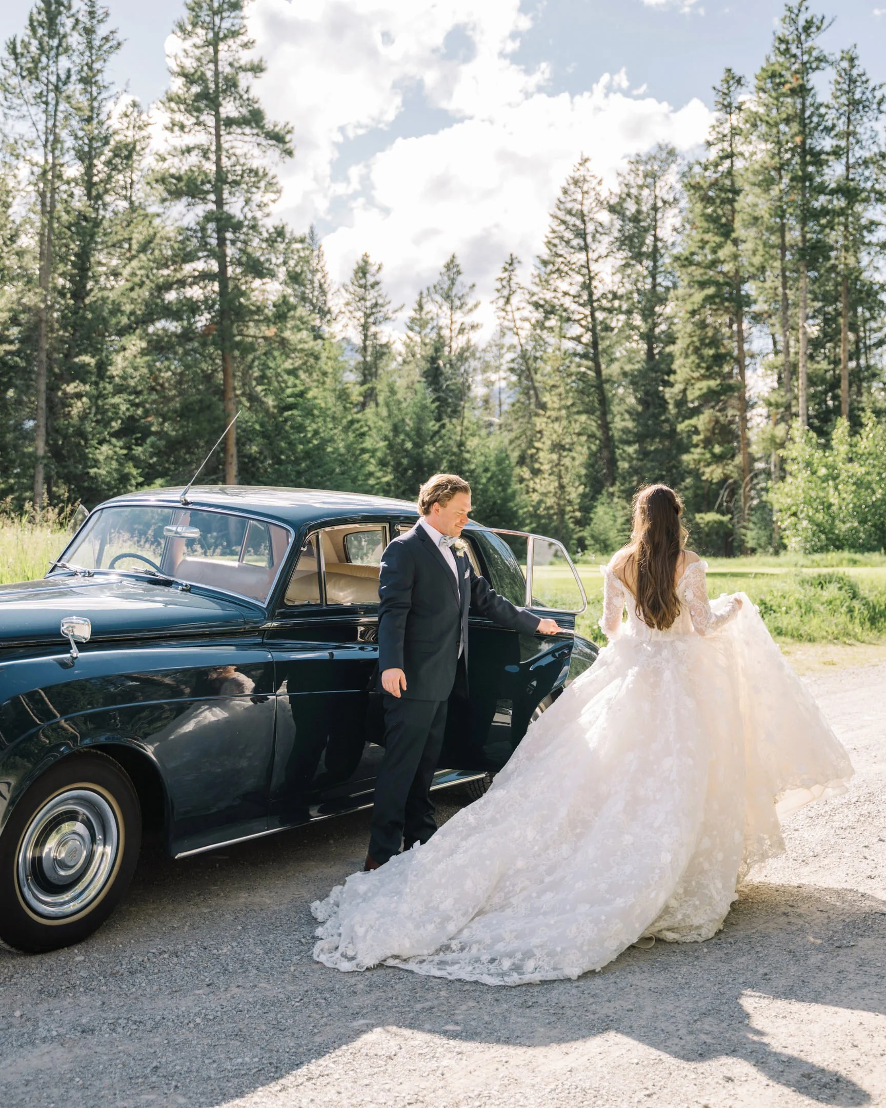 Bride and groom with vintage blue car in Canmore