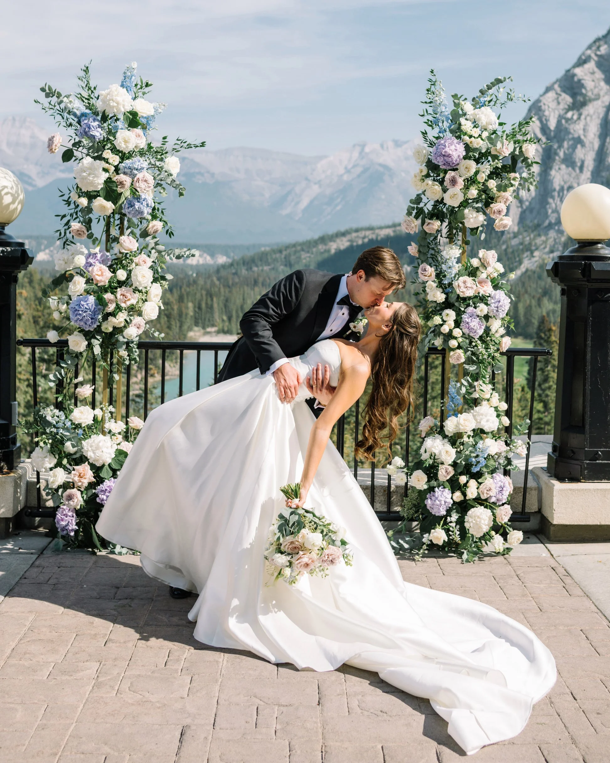 Bride and groom first kiss on the terrace at Fairmont Banff Springs