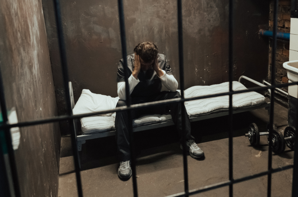 Man sits in prison cell lonely and sad