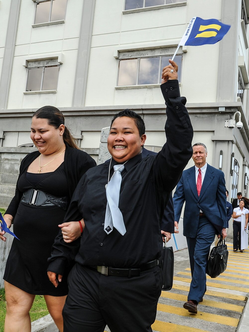 Loretta Pangelinan waves miniature equal rights flag as her and Kathleen Aguero exit court after ruling.