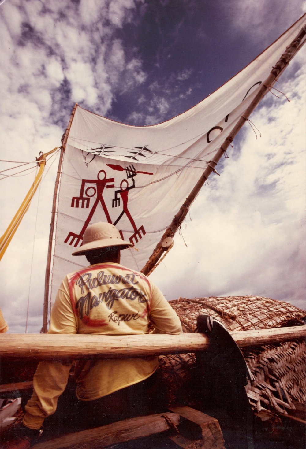  During the Polowat to Guam leg of Voyage ‘87, Master Navigator Rapwi Yaluwairh guides the sailing canoe, ‘Video.’ The design on Video’s sail is based on a petroglyph from Gadao’s Cave, Guahan. Photo by Rob Limtiaco © 