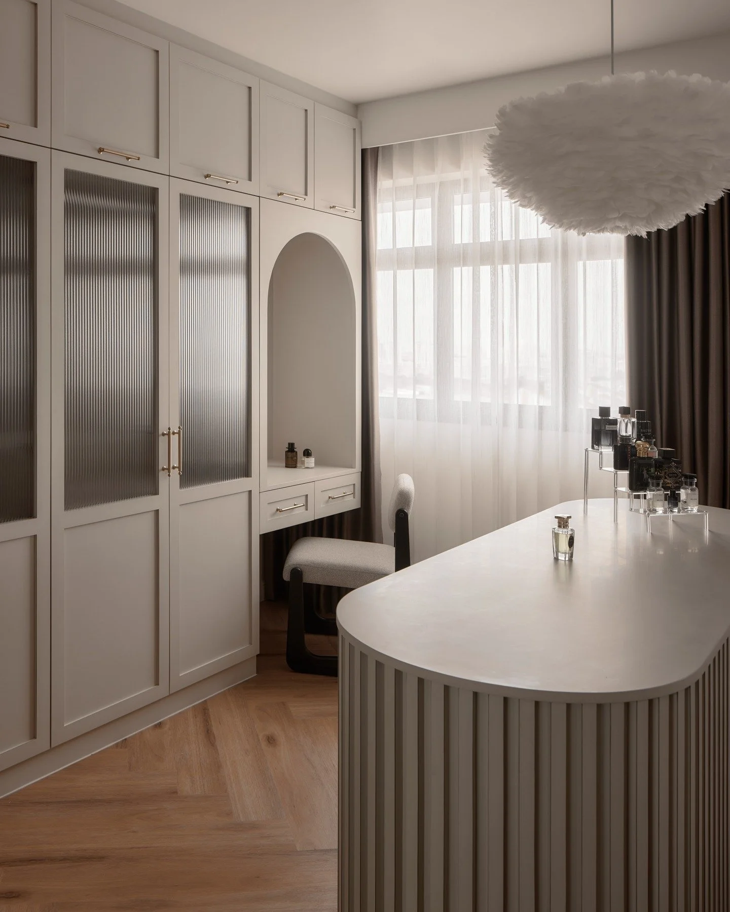 The bedroom island is only made possible by combining two rooms, so the homeowners have a lovely view to wake up to everyday.

The fluted glass was chosen to match the handmade fluted panels on the island while one laminate was used throughout to enh