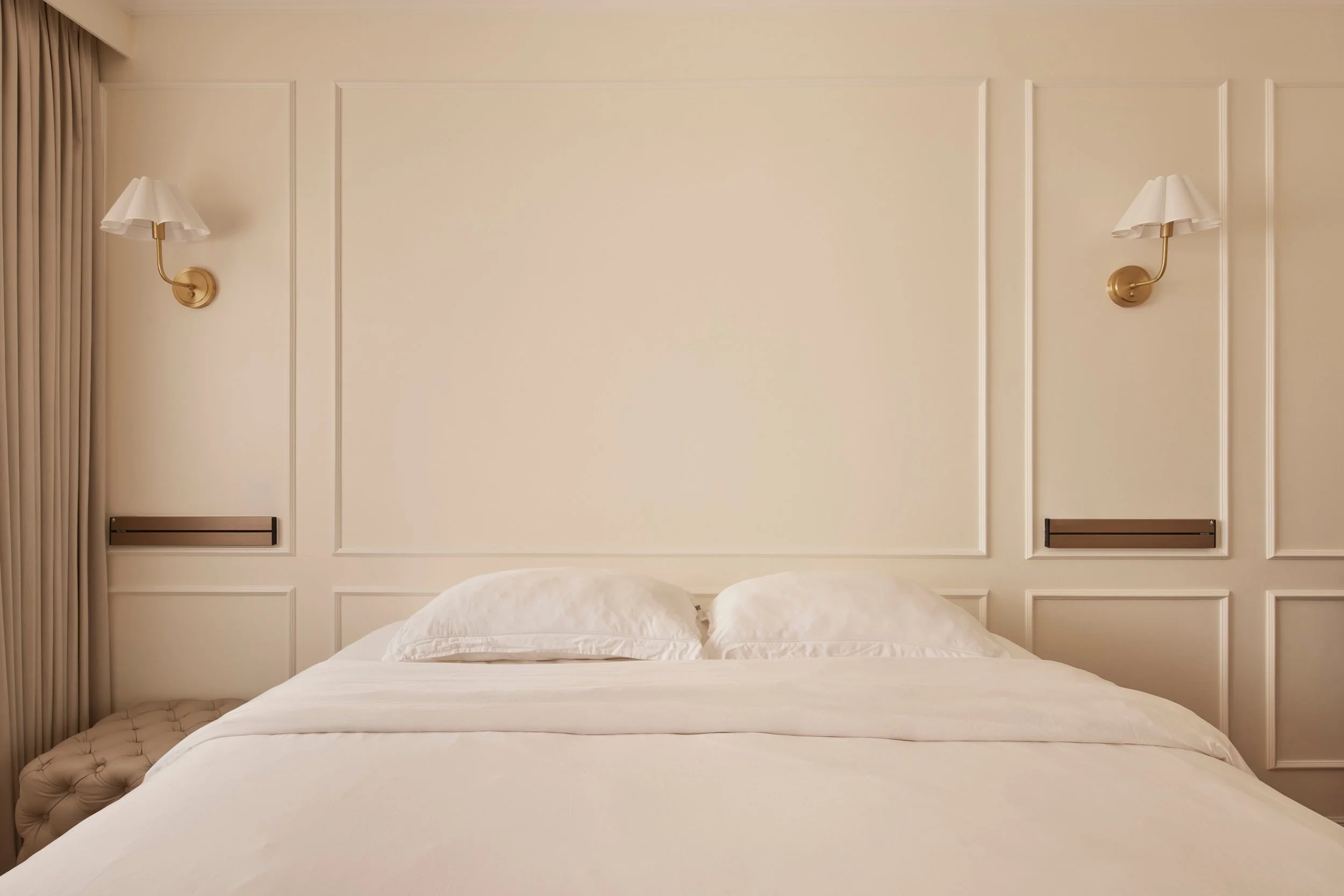 It was common in the 1970s for couples to hang their marriage day photo above the bed. It's since gone out of style and unlikely to make a comeback.

Leaving negative wall space for future art or other pieces is still a good idea though.

Whether its