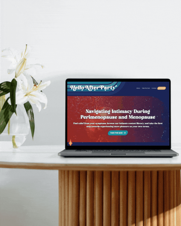 Laptop on a wooden table displaying a website about navigating intimacy during perimenopause and menopause, with a vase of white lilies on the side.