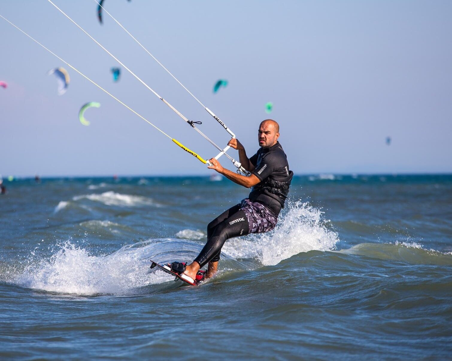 Konzentrierter Kitesurfer trainiert in kleiner Welle