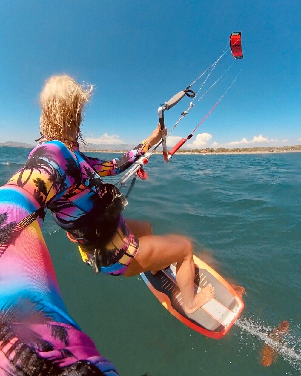 Farbenfrohe Kitesurferin auf einem Foilboard
