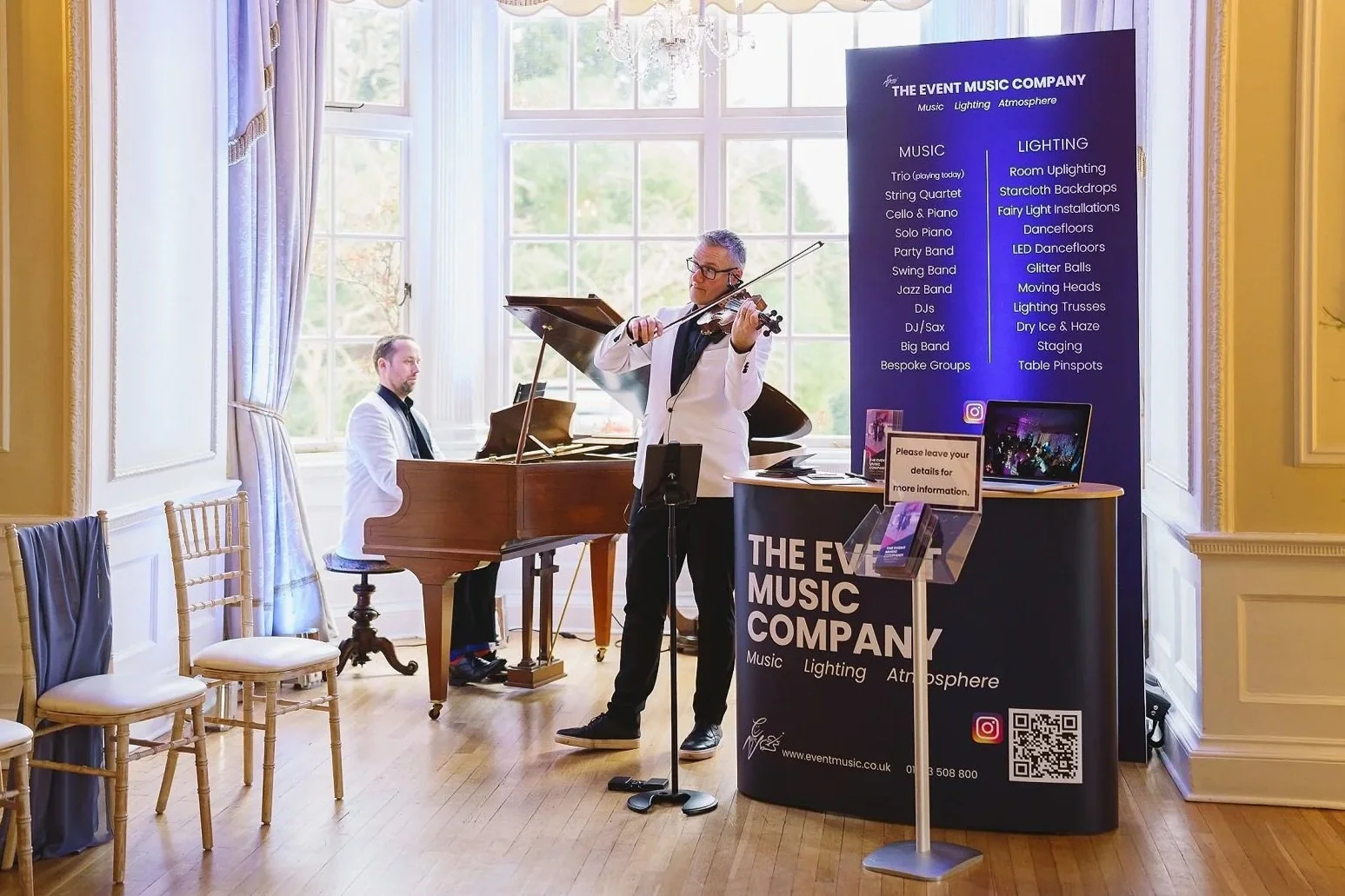 Image shows a man playing the violin and another the piano in the drawing room at wedding venue Goldsborough Hall