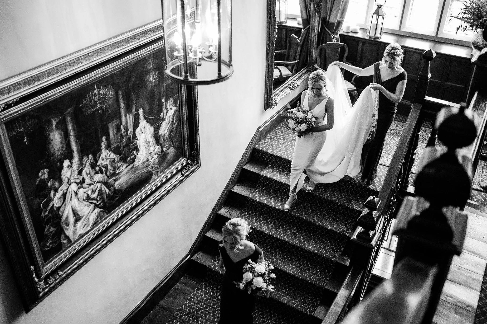 Bride and bridesmaids descending down an old staircase prior to a wedding