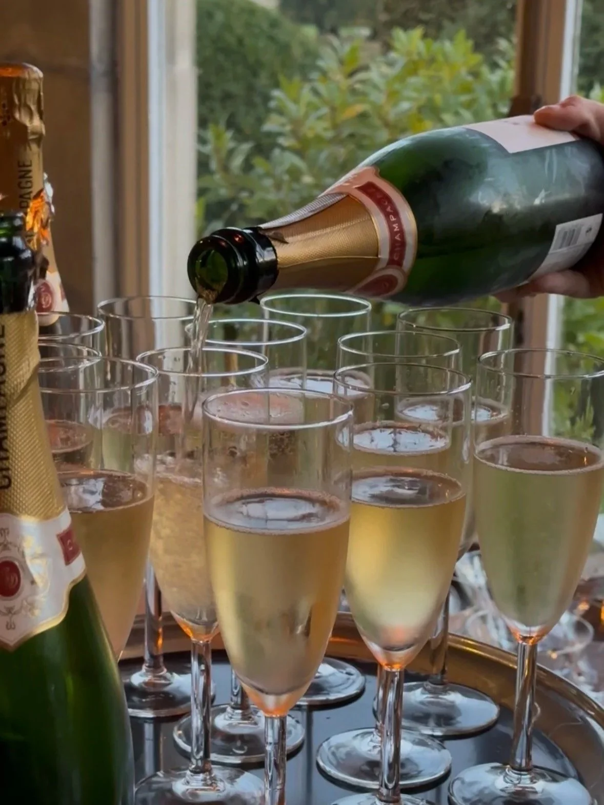 image shows lots of glasses of champagne and someone pouring champagne into a glass at Goldsborough Hall