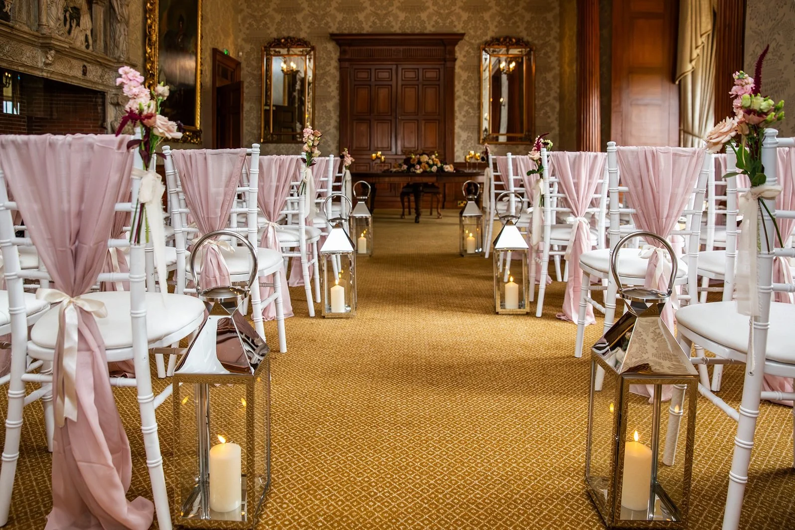 a civil ceremony in the dining room at Goldsborough Hall with white chiavari chairs, blush pink sashes, lanterns along the aisle