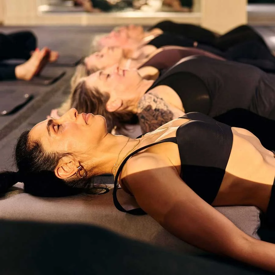 A group of women reclining in a yoga pose