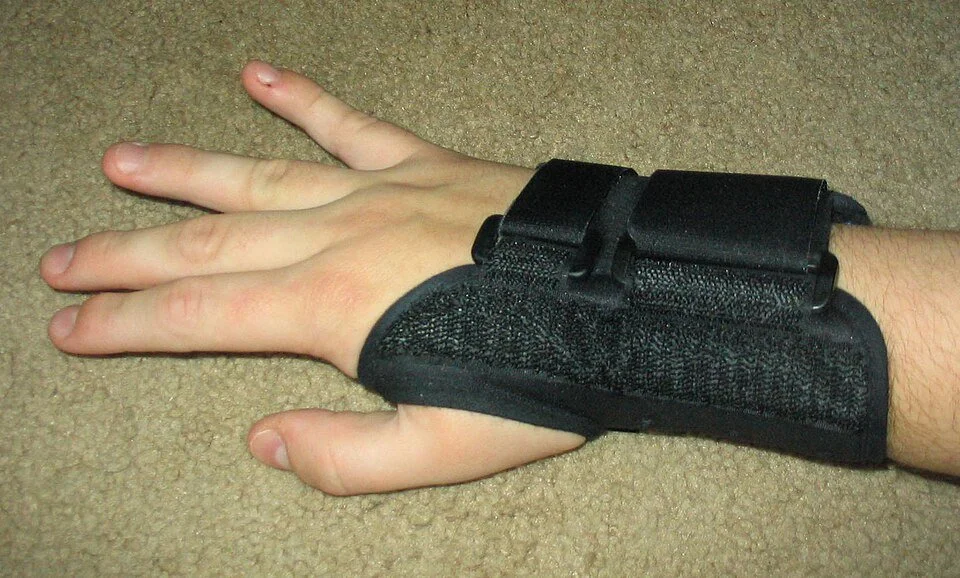 Photo of a hand and wrist in a black wrist splint.