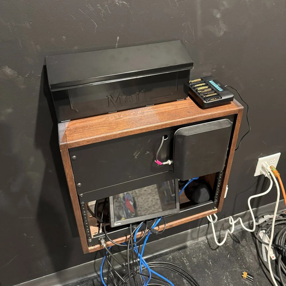 The Student Union equipment hub with a black mailbox, projector remote, microphones, batteries, and cables.