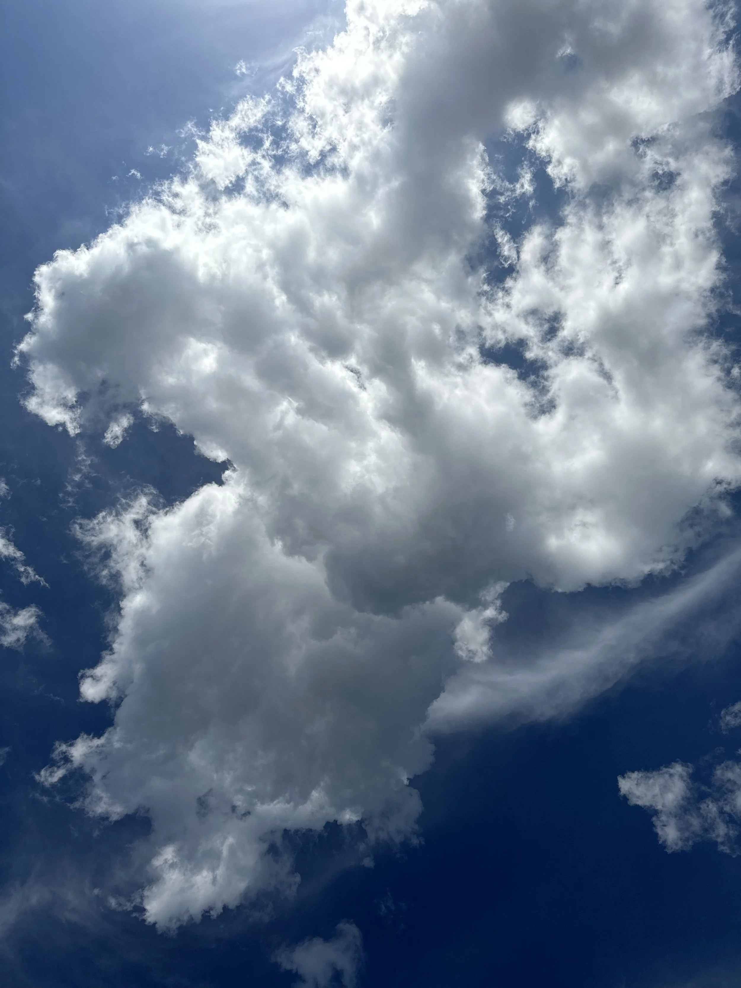 Sky with large fluffy white clouds and patches of blue sky.