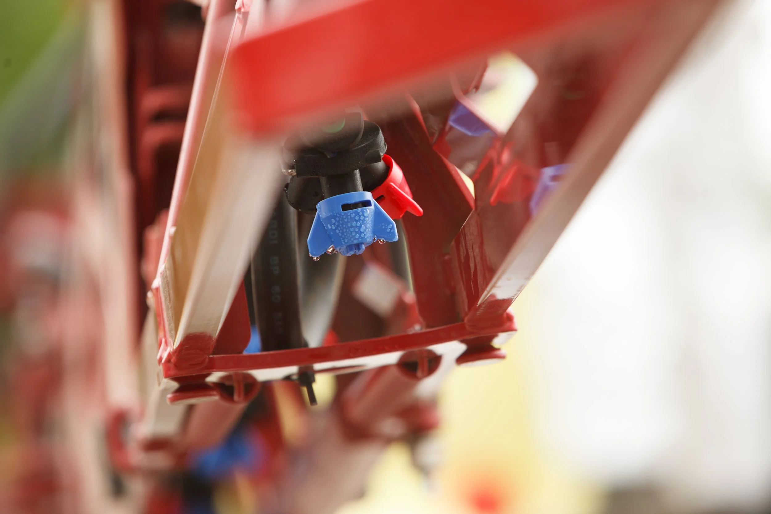 Close up shot of nozzles mounted on a sprayer boom