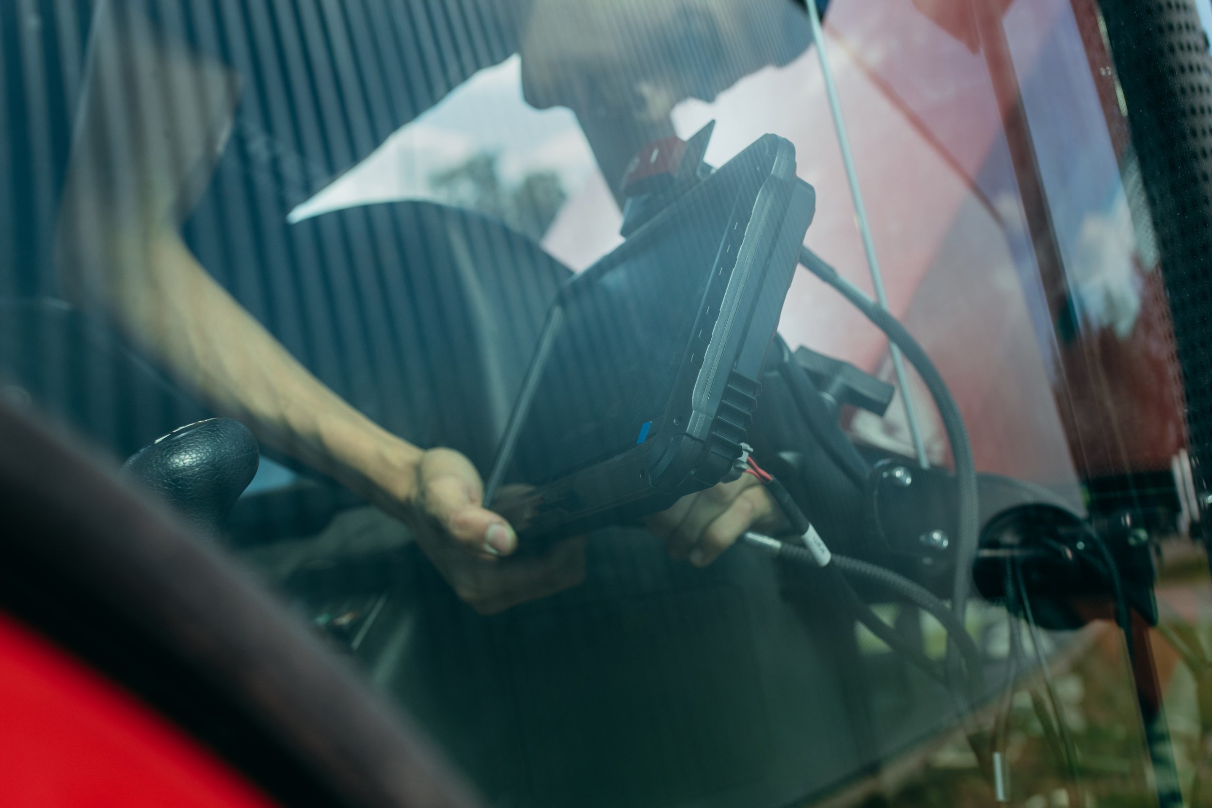 Farmer installing new monitor in tractor cab