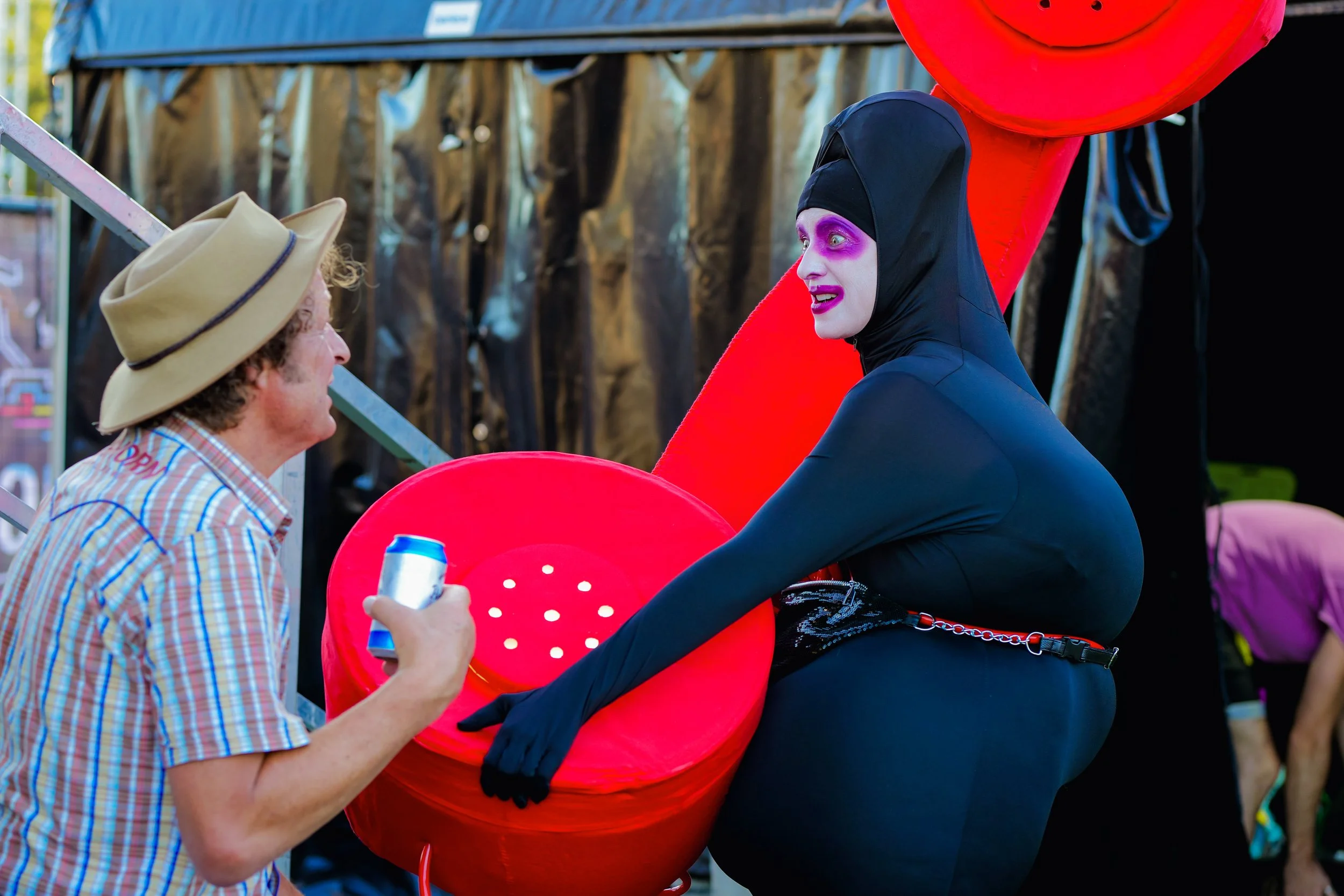 Alicia holding telephone chatting to a man at festival