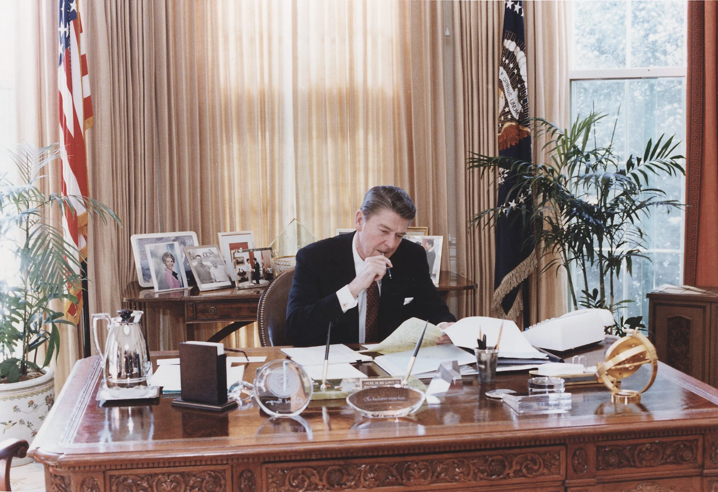 Photograph_of_President_Reagan_working_at_his_Oval_Office_desk_-_NARA_-_198526.jpeg