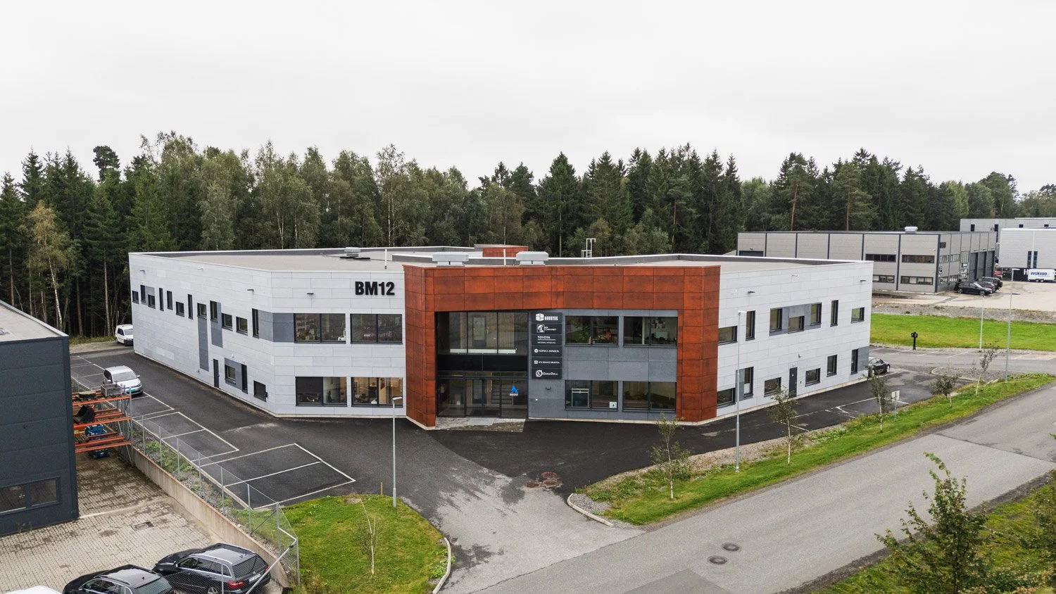 Moderne kontorbygg med rustrød hovedinngang