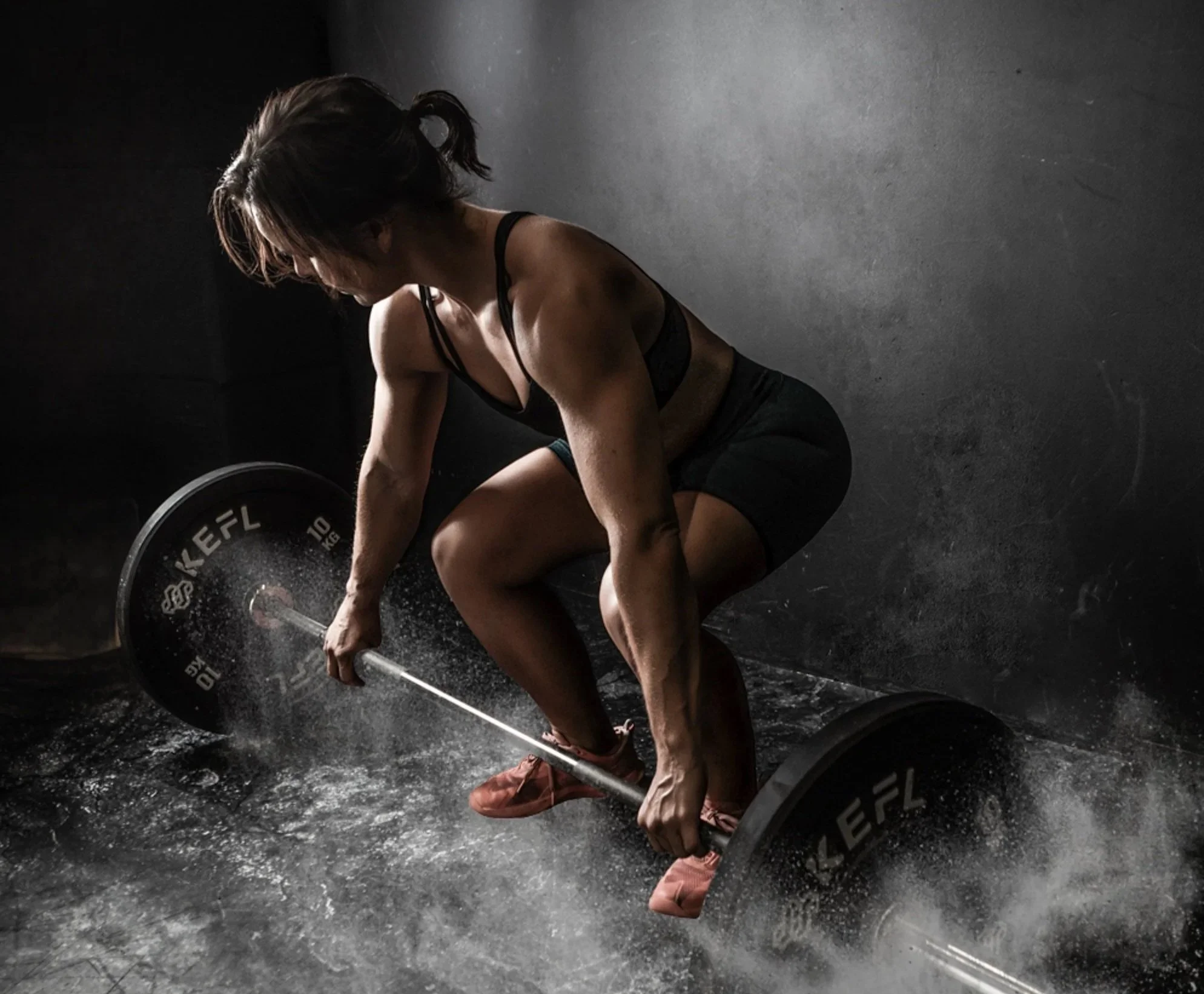 Fit woman lifting a heavy weight during an empowerment boudoir photoshoot in East Sussex