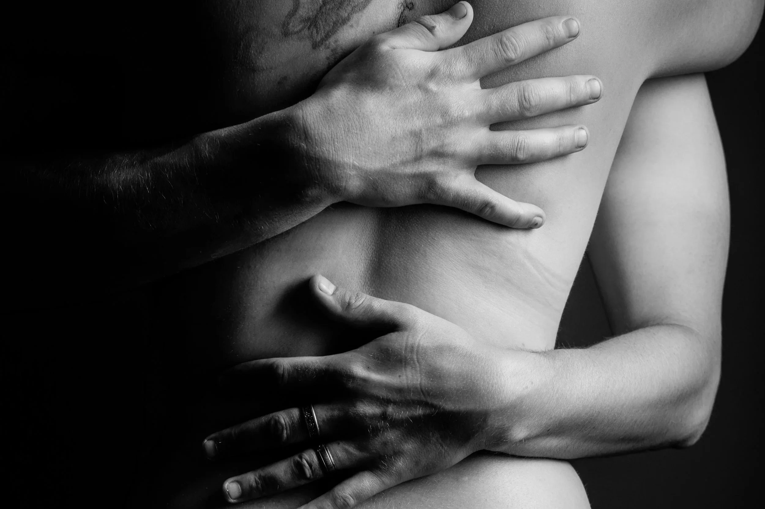 Close-up of a couple embracing during an artistic boudoir photoshoot