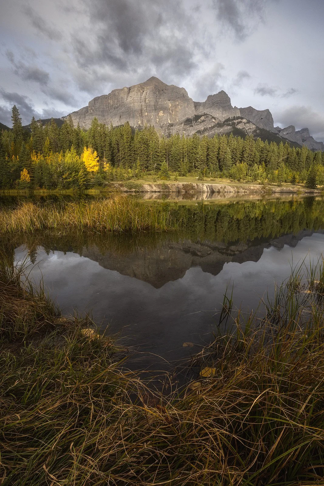 Quarry Lake – Autumn Reflection of Rocky Mountain Peaks Beneath Brooding Skies in Canmore.jpg