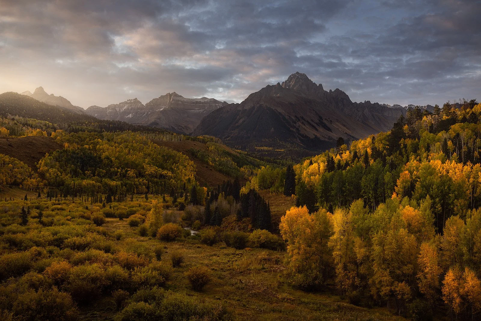 Colorado San Juans – Autumn aspens and golden hills below the jagged peaks at sunrise.jpg