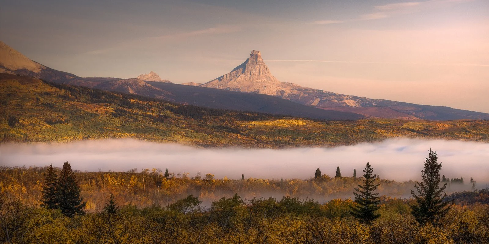 Chief Mountain – Towering butte above golden autumn canopy and valley fog in Glacier National Park.jpg