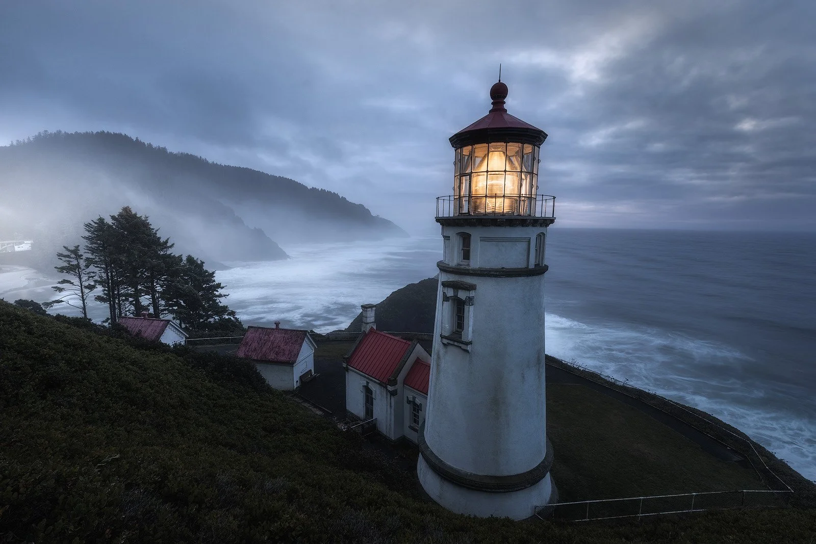 Lighthouse guiding through coastal mist at dawn on the Oregon coast.jpg