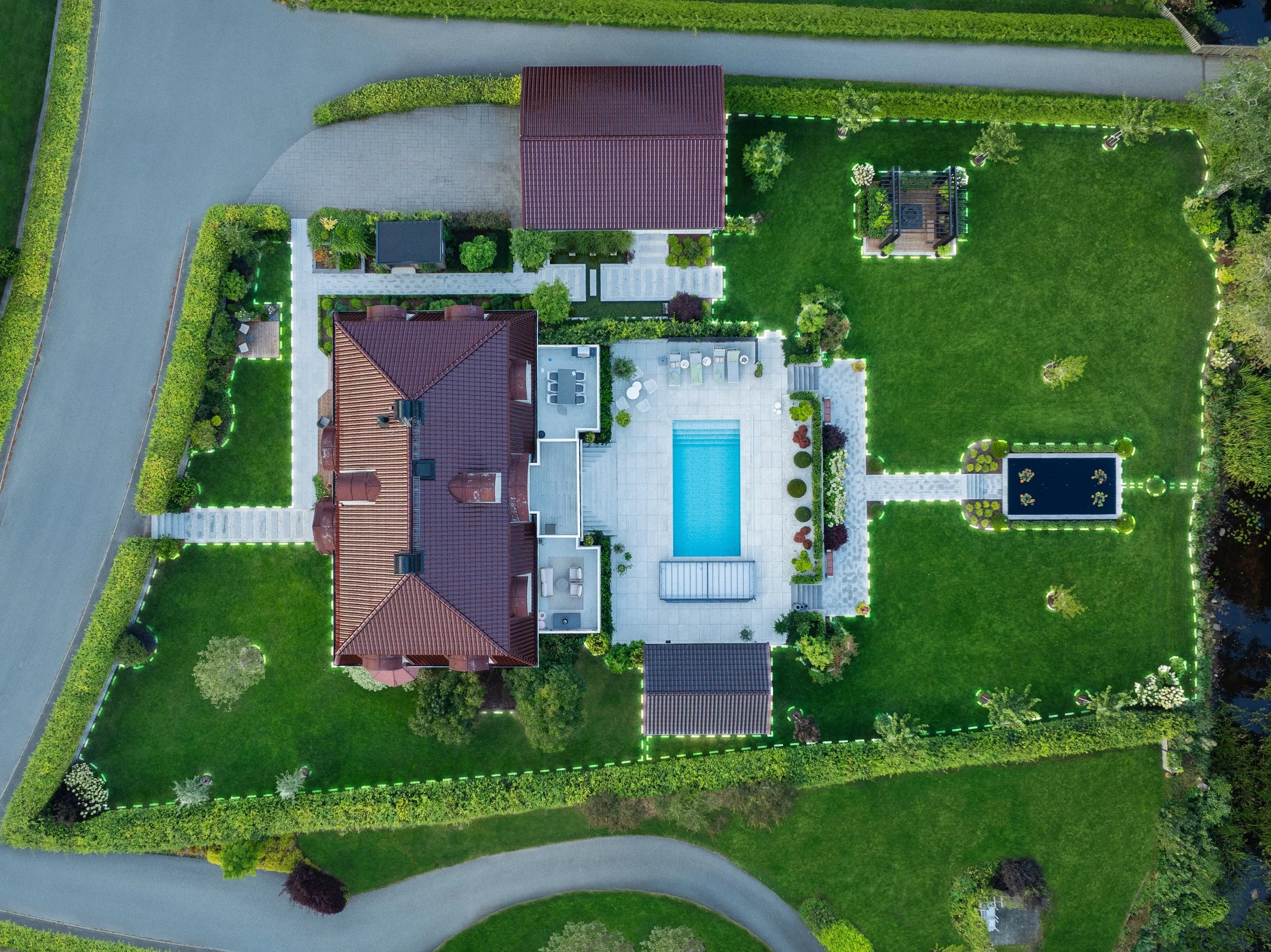 Aerial view of a large property with a house, swimming pool, and landscaped garden.