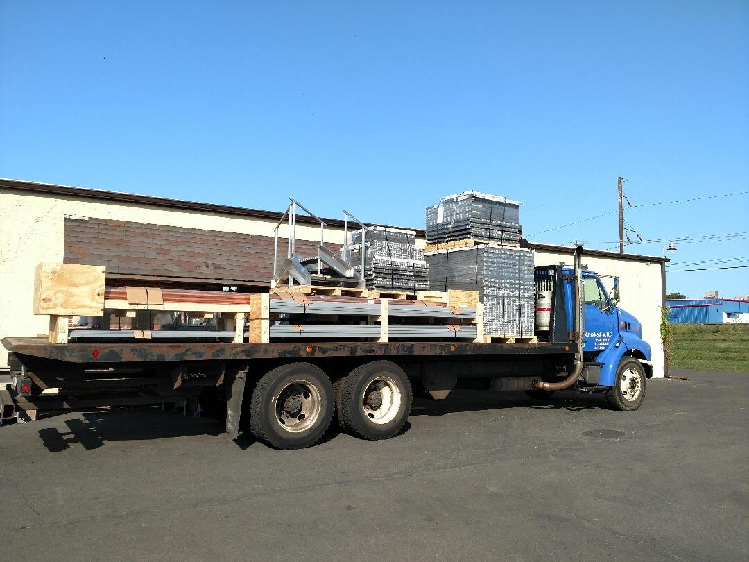 Flatbed truck loaded with pallets and metal materials