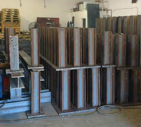 Stacked steel I-beams in a warehouse setting