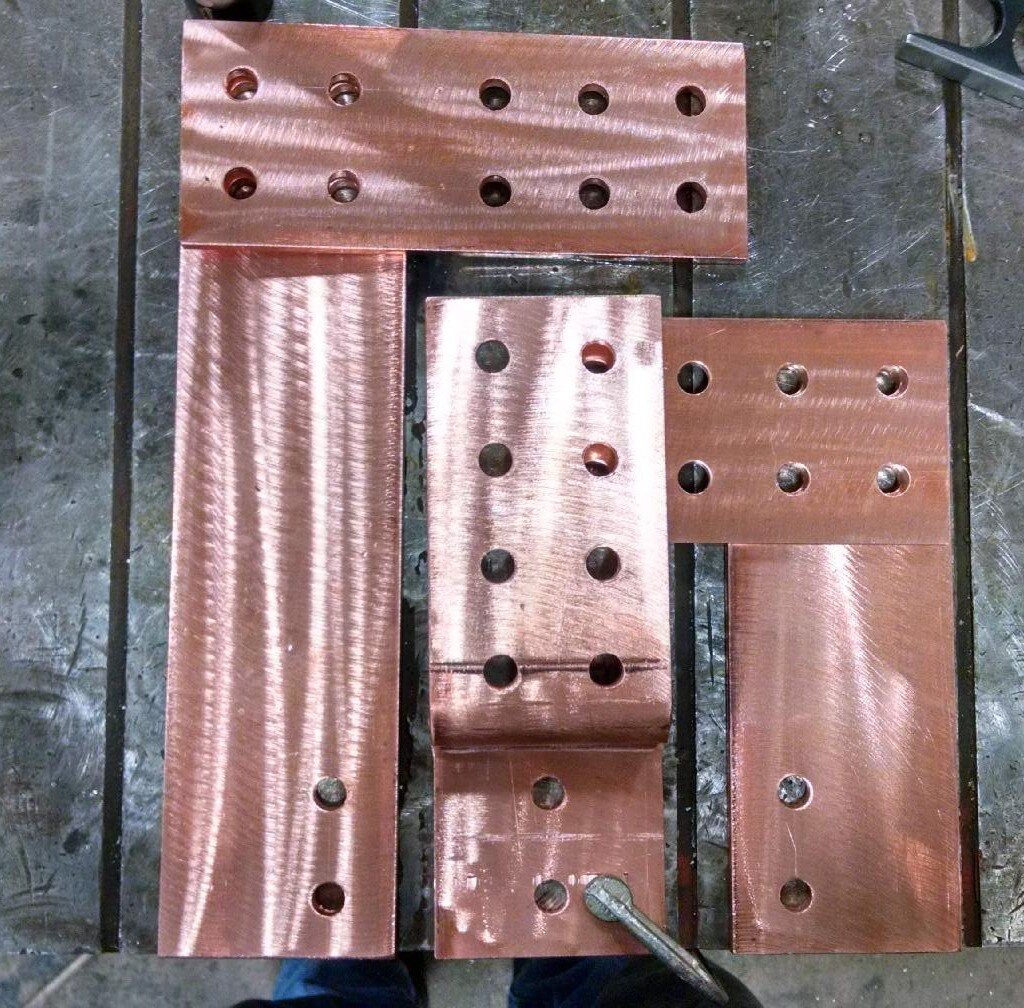 Copper plates with drilled holes on a metal surface