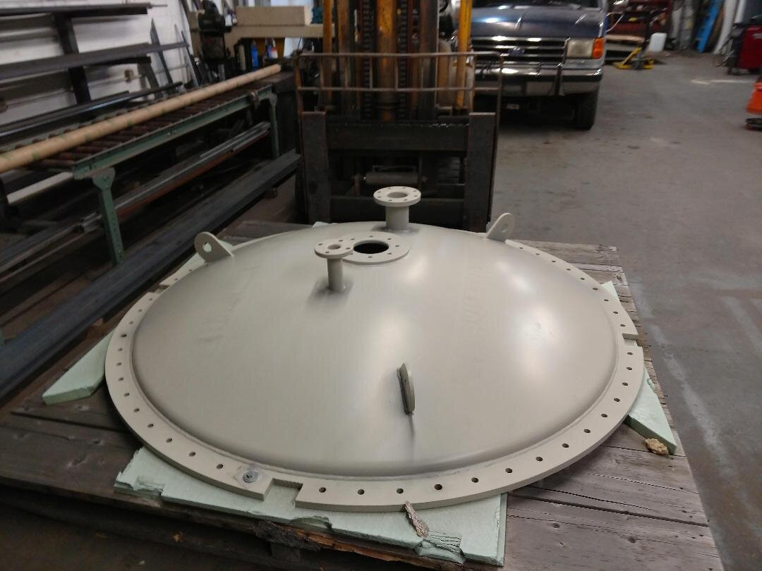 Industrial metal lid or cap on a pallet in a workshop