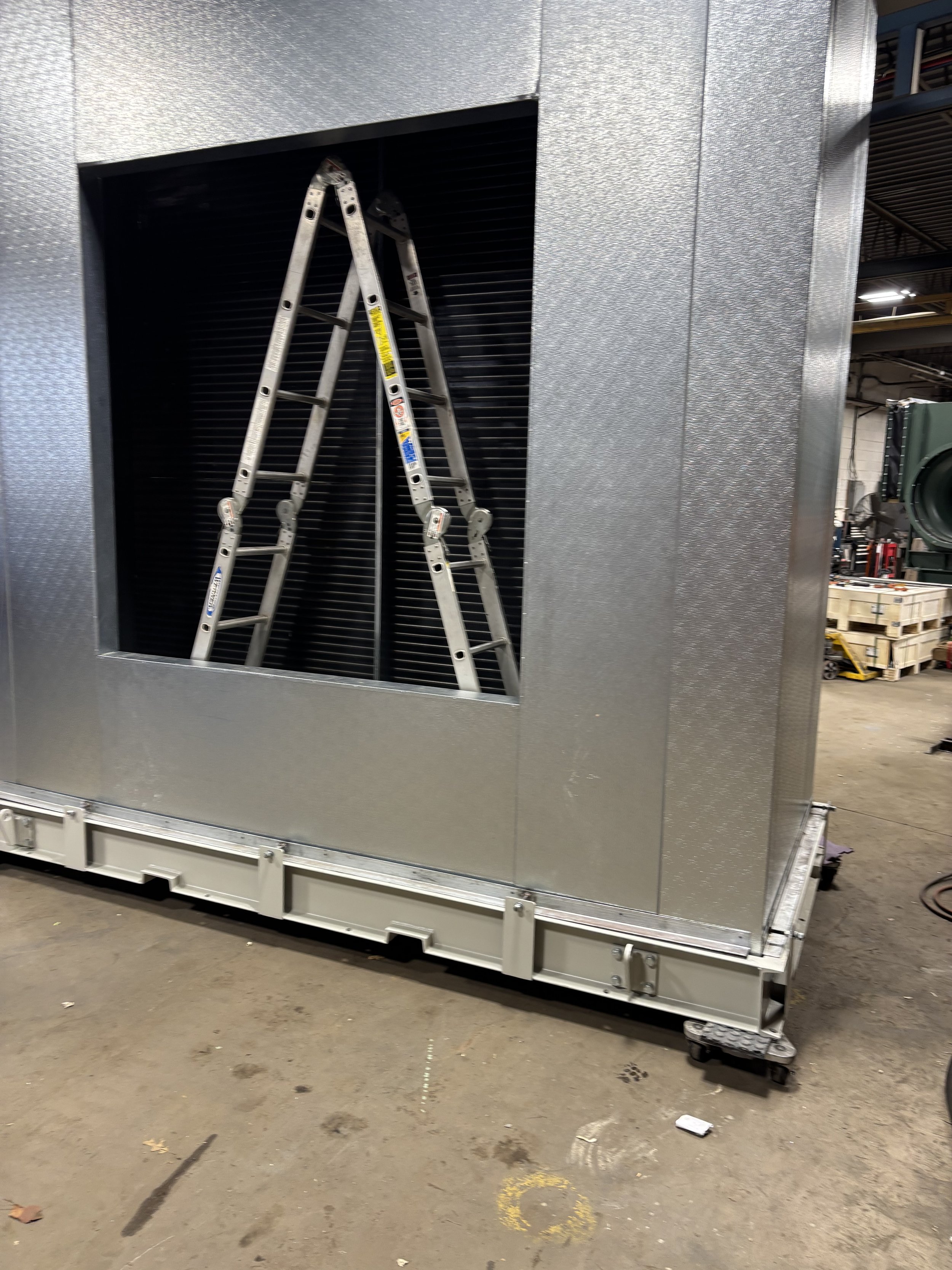 Metal structure with a ladder inside, industrial setting.