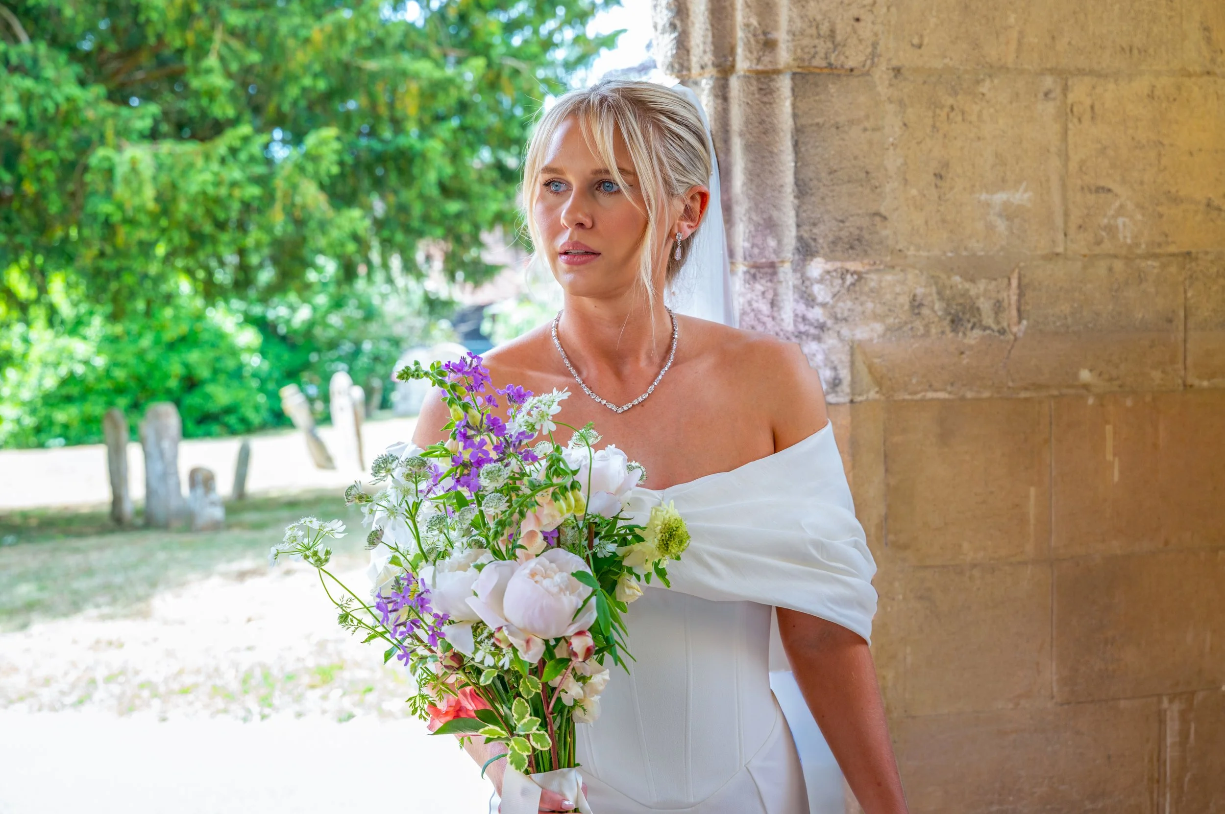 A young bride holding onto her flowers walks into church prior to her wedding ceremony