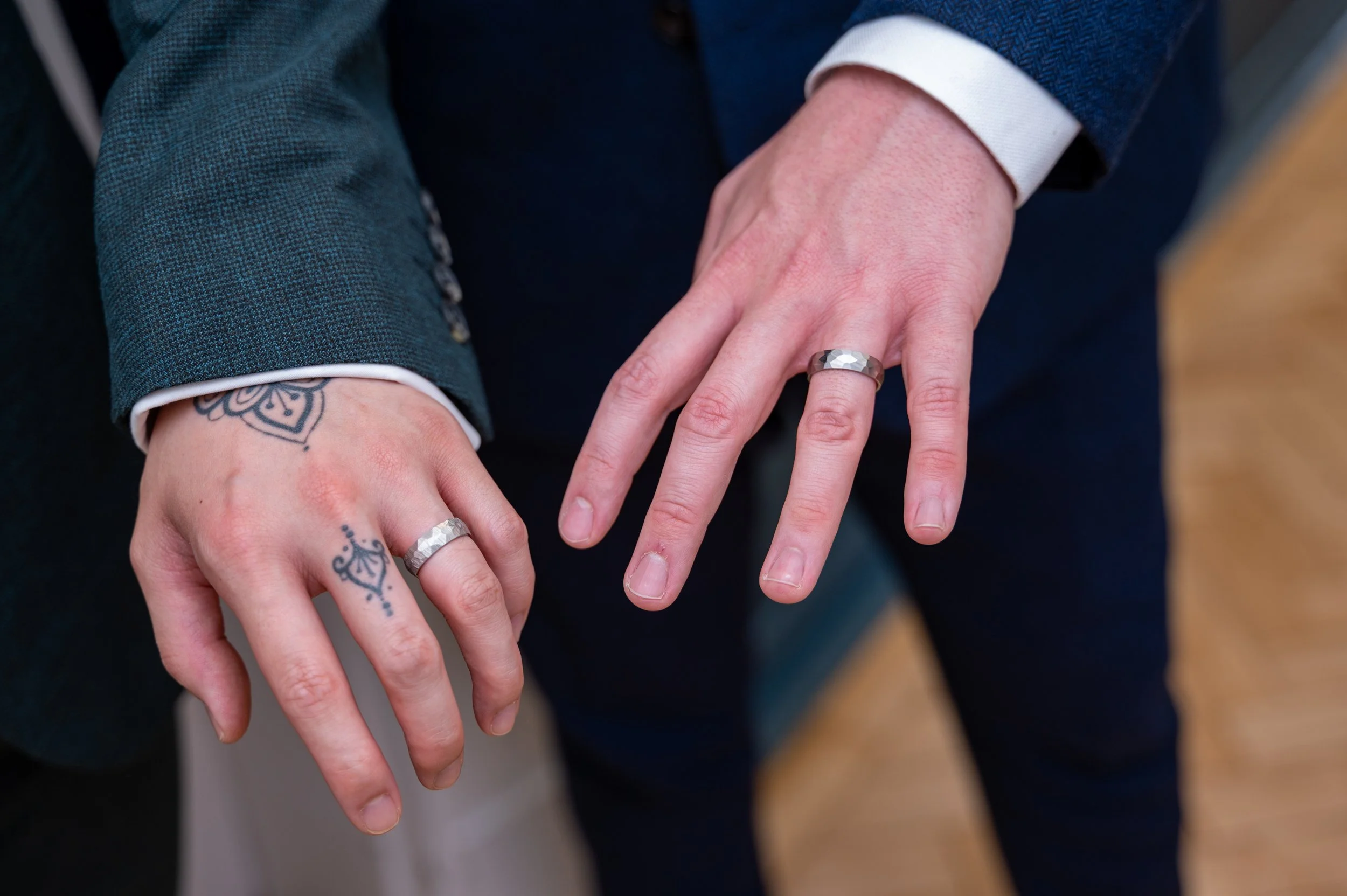 a close up of wedding rings on a same sex couple who have just got married
