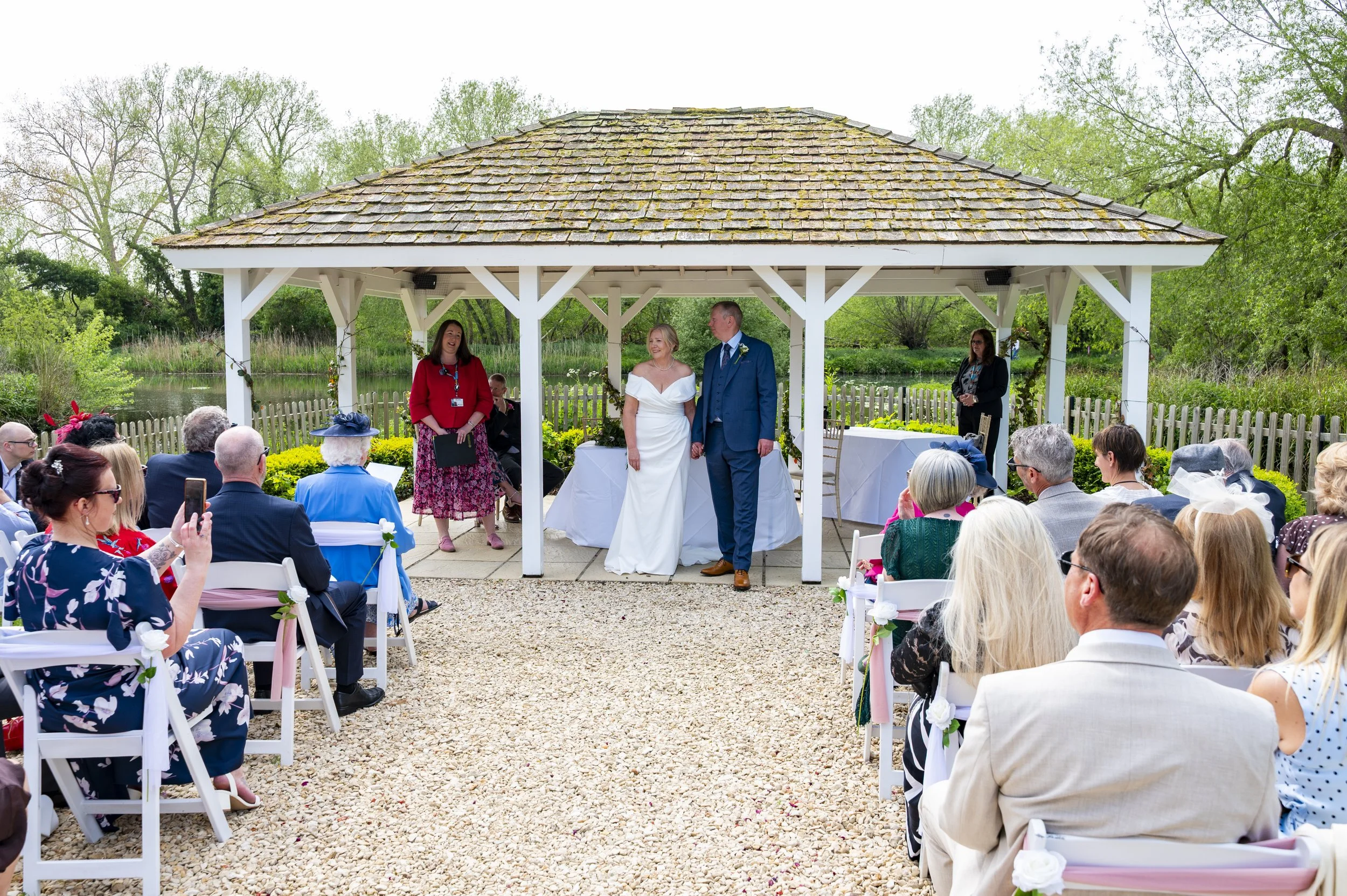 a couple stand in front of their guests during an outside summer wedding