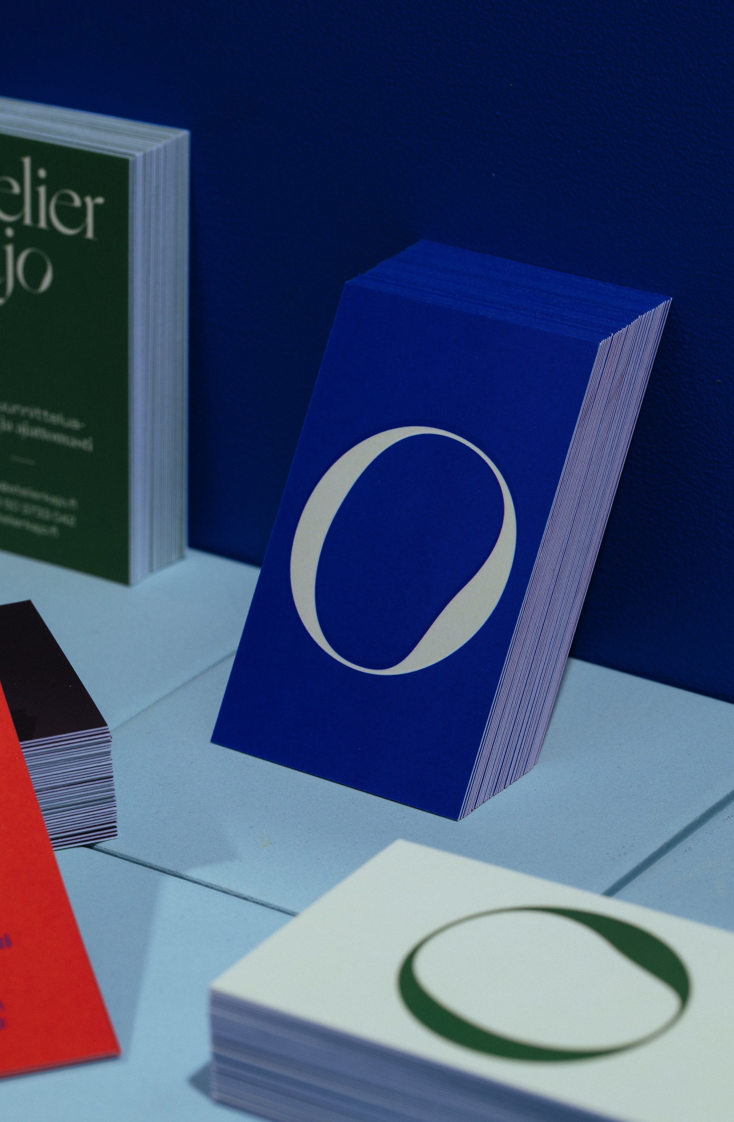 Close-up of the edges of colorful cards or booklets with various designs, stacked on a white surface.