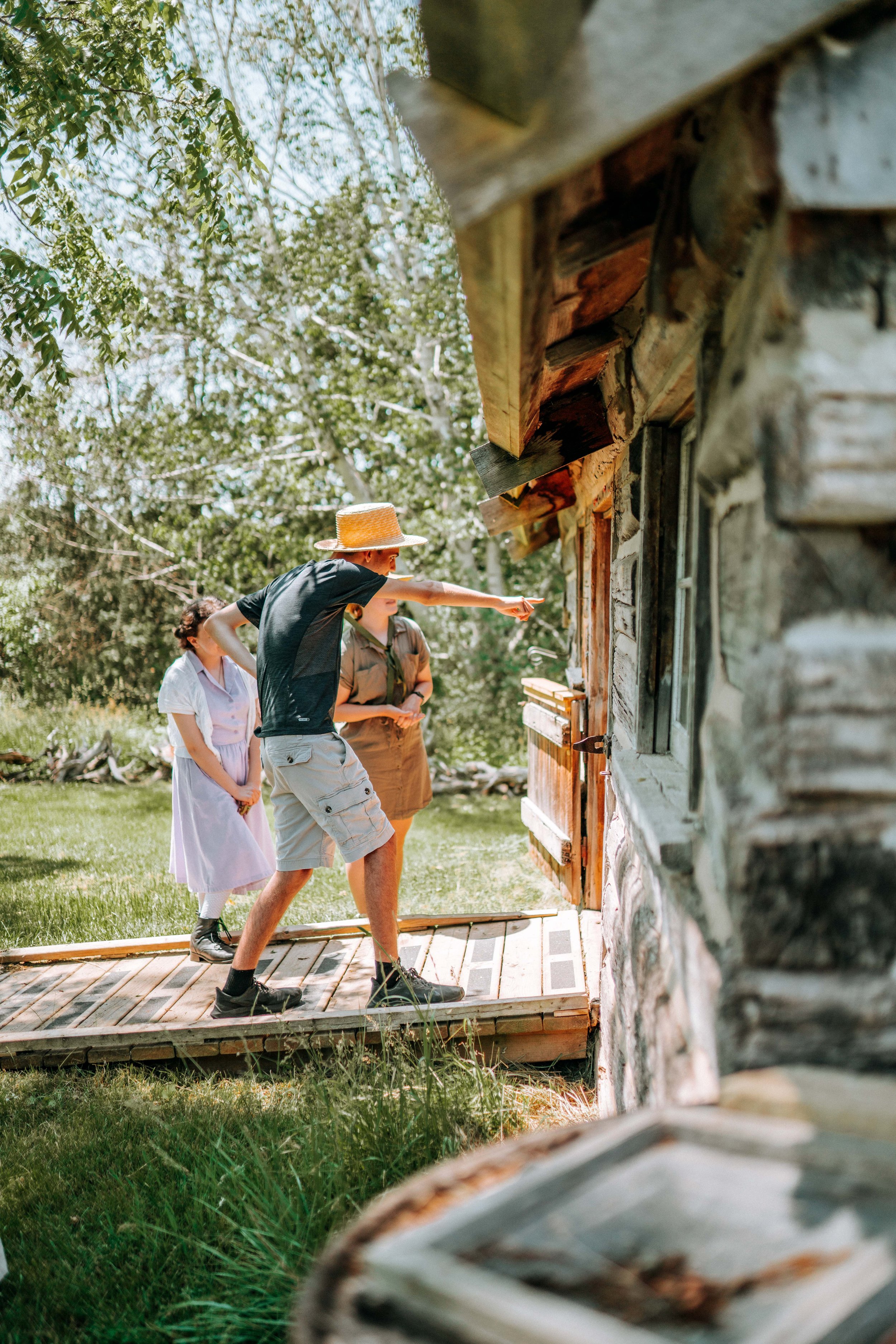 A group of visitors enter the log house.