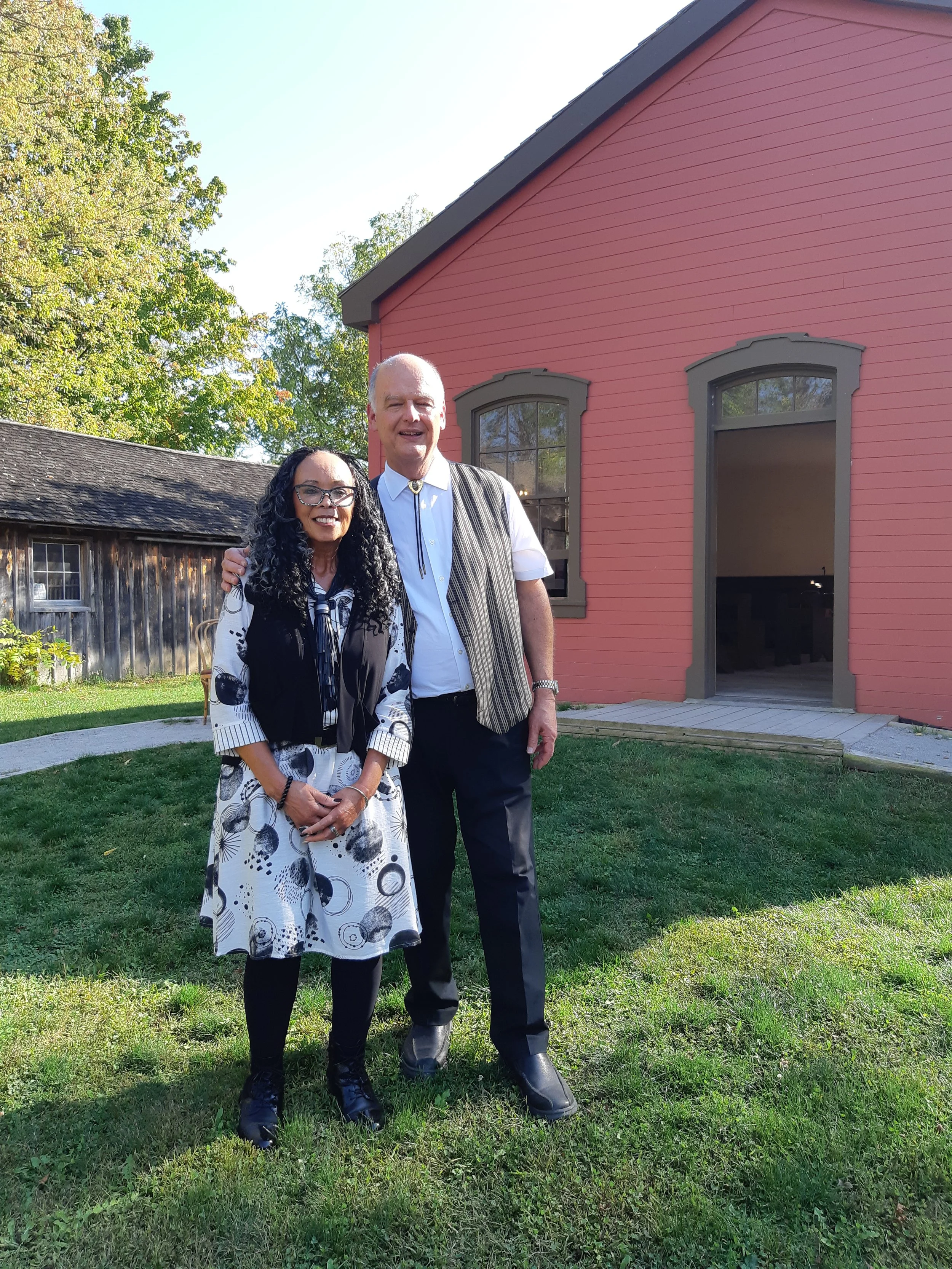 A photo of Denise Pelley and Stephen Holowitz in front of the AME Church.
