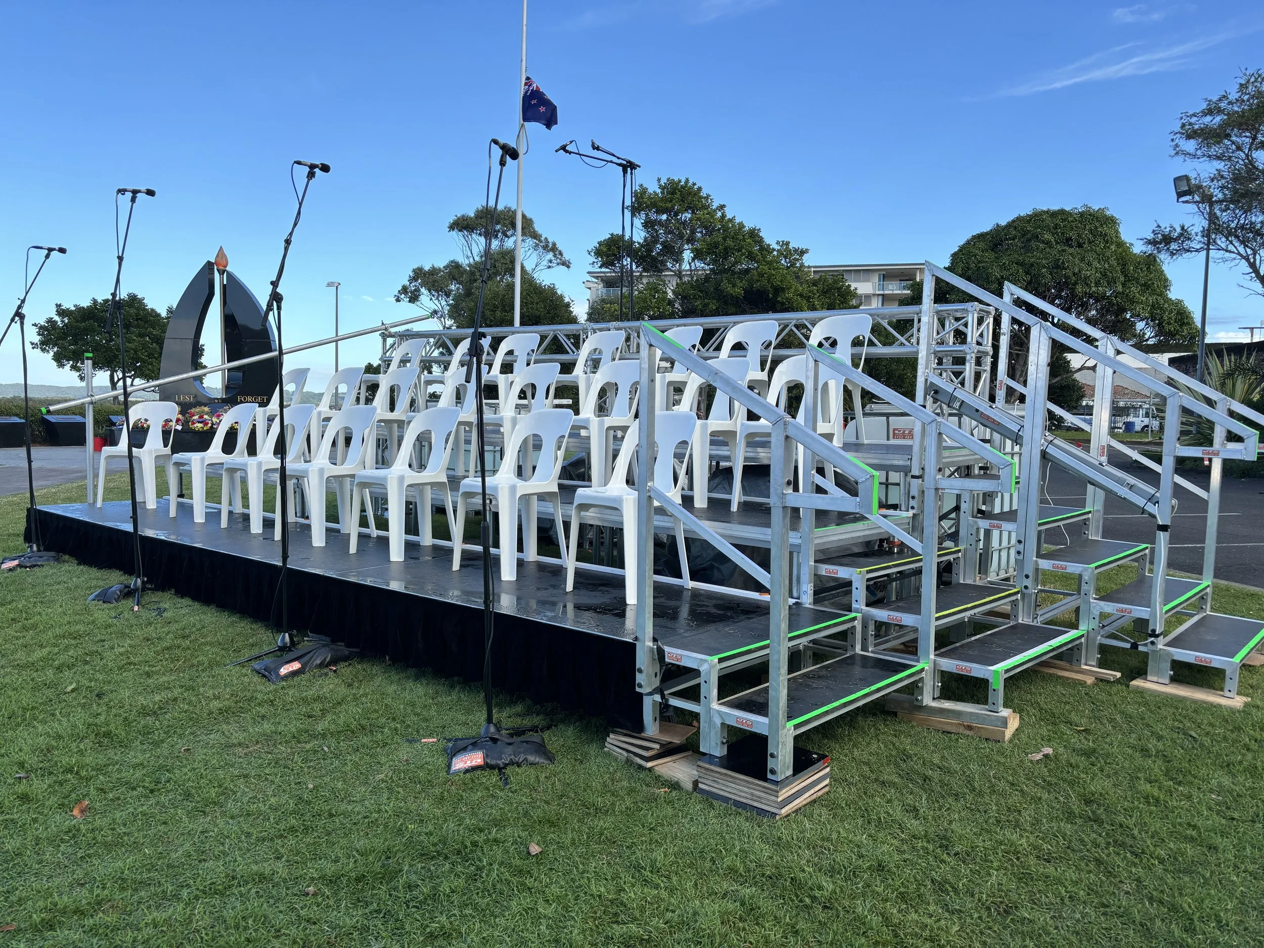 Outdoor stage setup with chairs and microphones ,set up for a choir in an outdoor soace