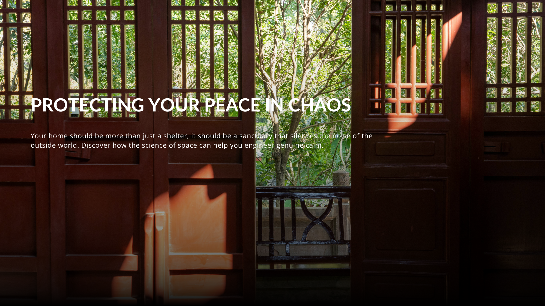 A view looking out from an interior space through open, dark-wood lattice doors onto a bright garden with sunlit trees.