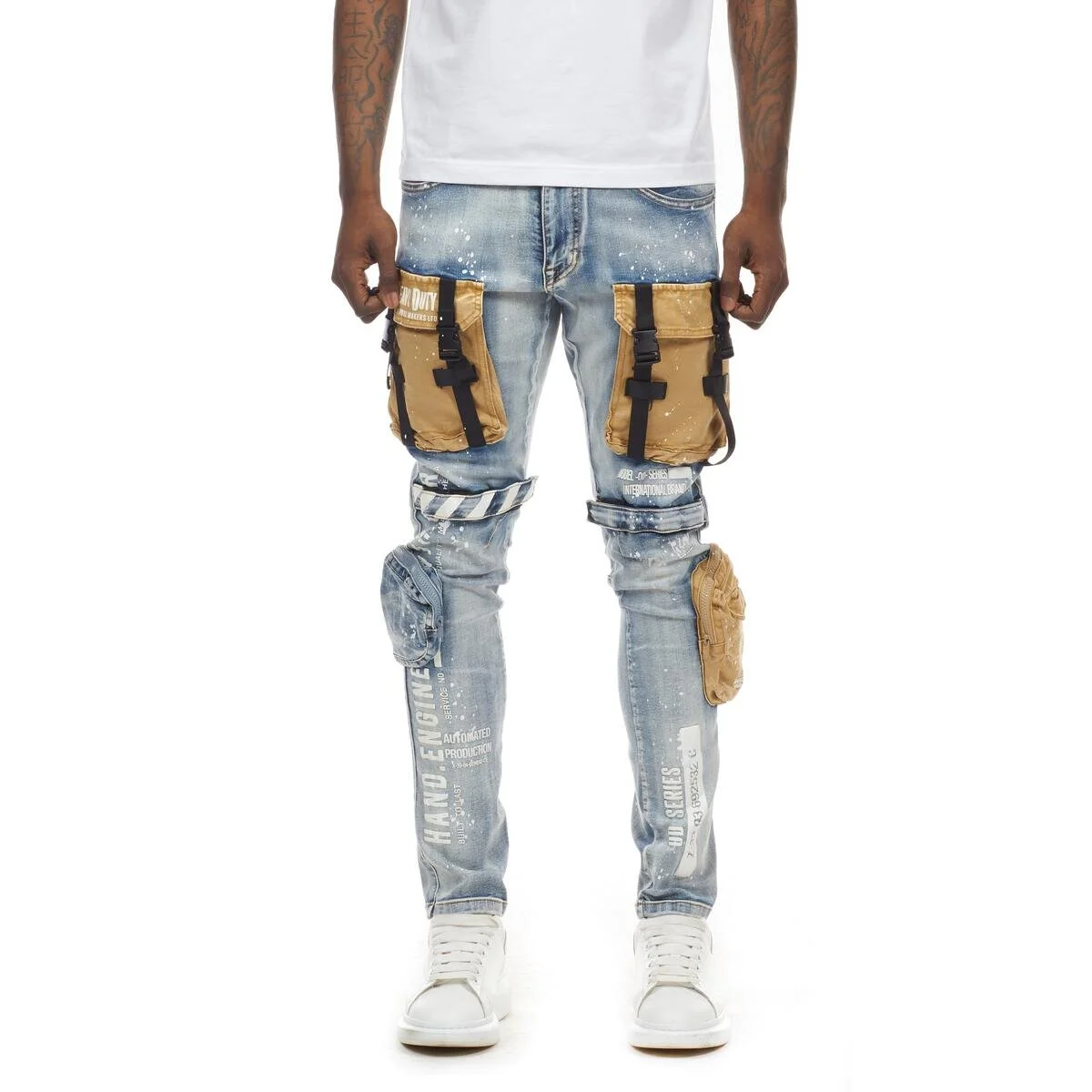 Person wearing distressed denim jeans with large brown utility pockets, white text prints, and a plain white t-shirt.