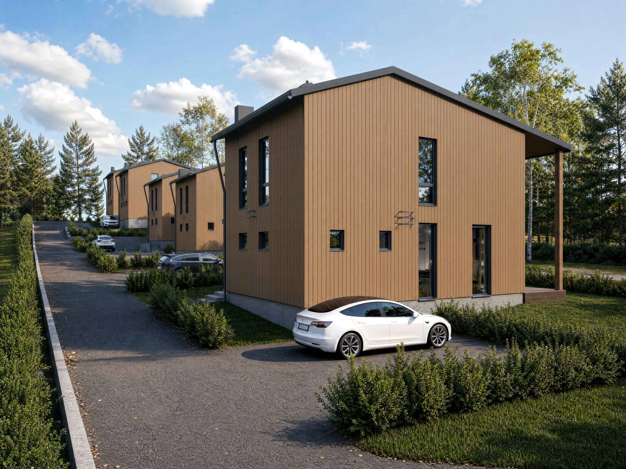 Moderni puurakennusalue, autoja pysäköity kulkuväylälle, ympärillä puita ja pihamaata.