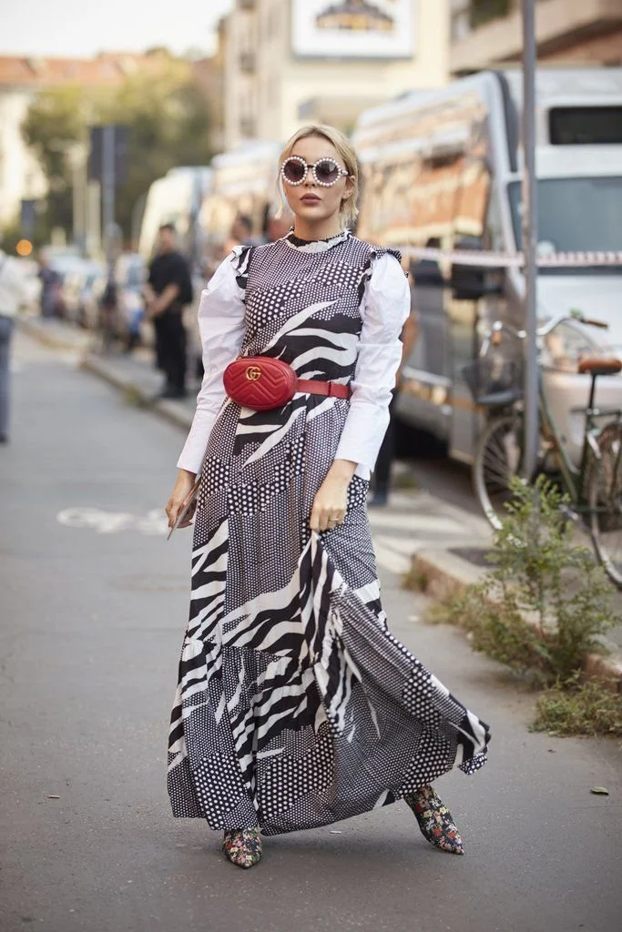 Belt bag cor de vinho combinada com vestido comprido estampado e botas altas..jpeg