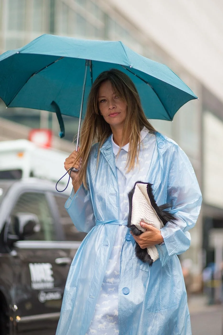 Guarda-chuva azul marinho em look casual com jeans e casaco impermeável..jpeg