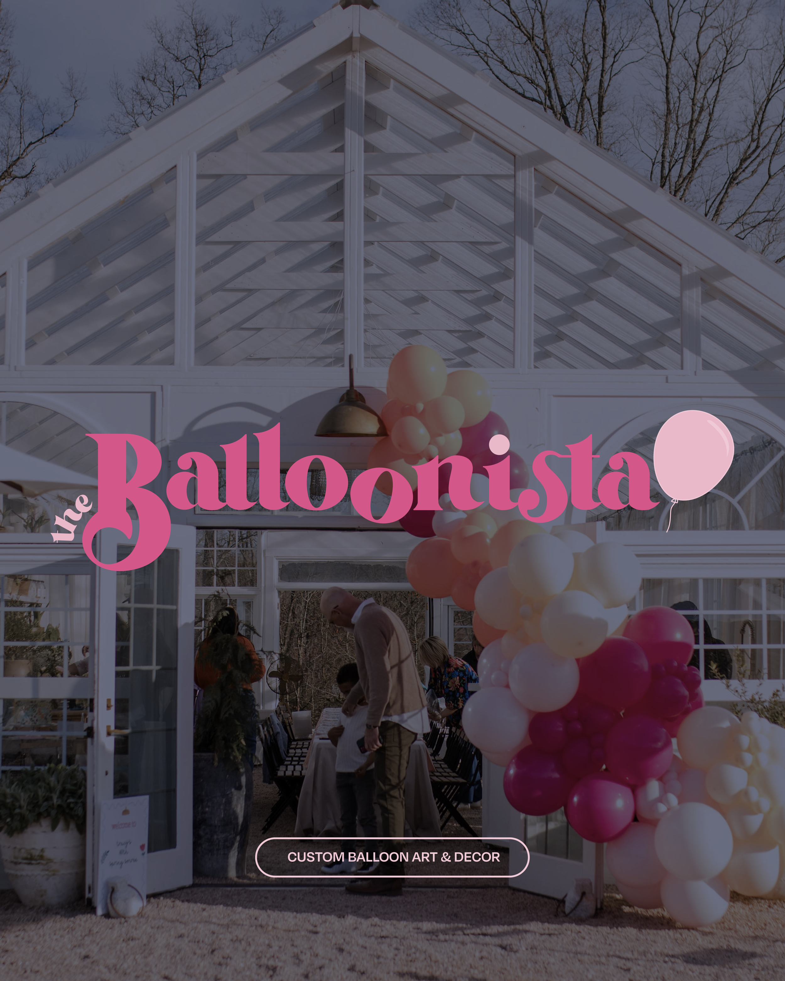 Event entrance with white archway decorated with pink, white, and peach balloons, sign reading "The Balloonista" and "Custom Balloon Art & Decor" in pink text, outside during daytime with leafless trees in the background.