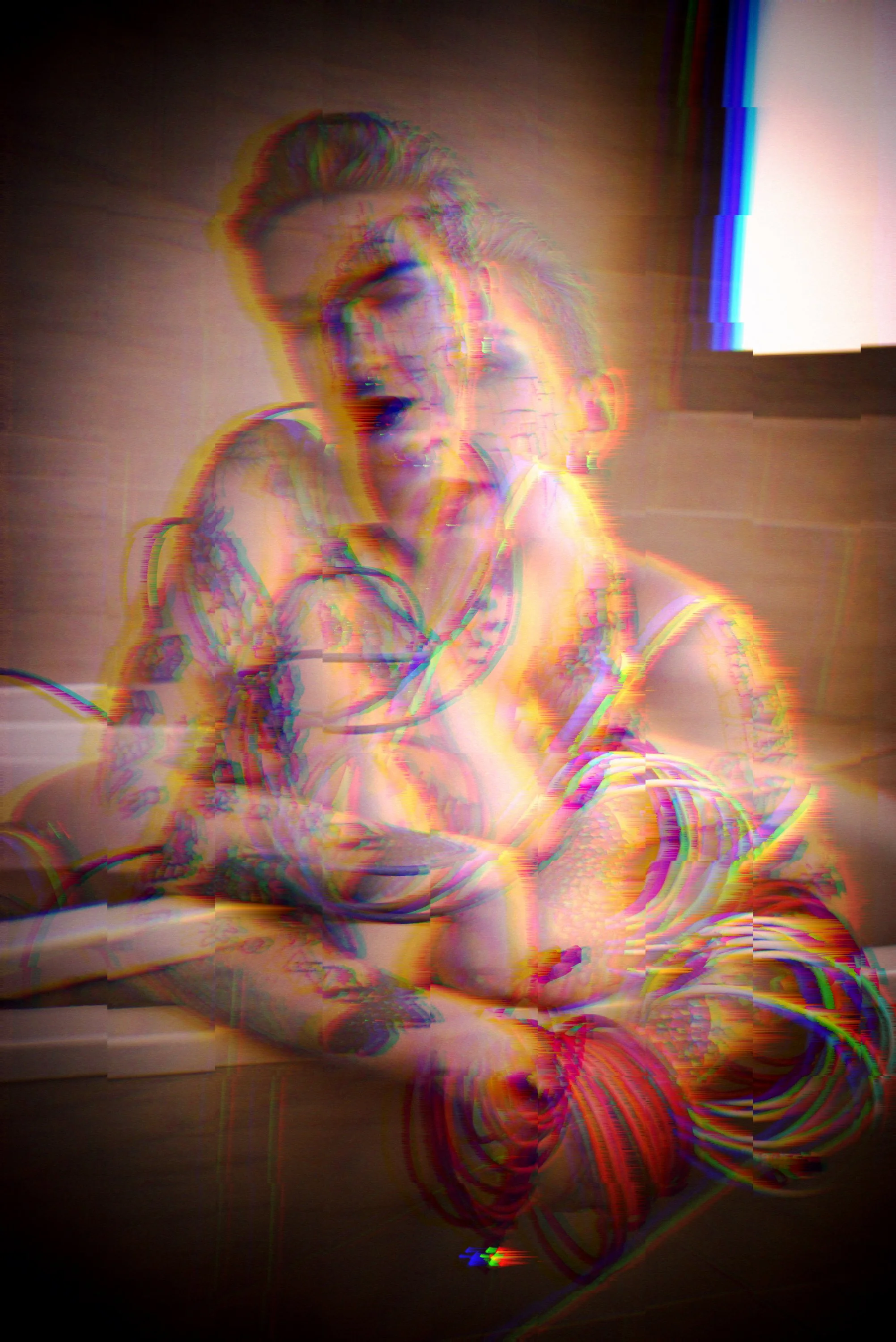 A distorted, glitched image of a person with blonde hair, sitting at a table with a claw near their face, in a smoky or foggy environment with bright lights and optical artifacts.