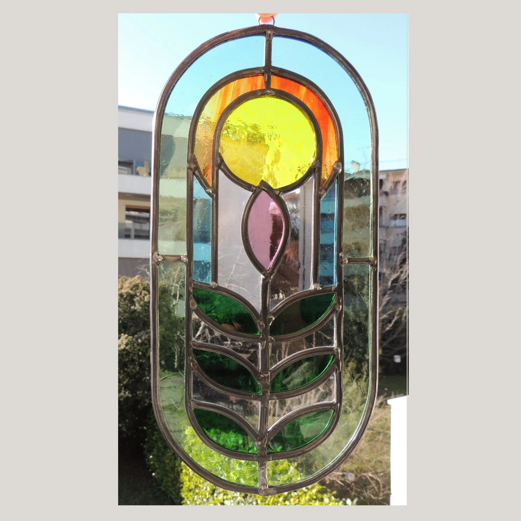 stained glass multicoloured oval pill-shaped pendant light catcher. Vetro colorato multicolore ovale a forma di pillola ciondolo, vetrate artistiche Charlotte Roden, Udine, Friuli Venezia Giulia FVG, Italia.